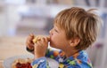 Food, breakfast and boy eating a sandwich in morning, pyjamas and home for nutrition. Children, hungry and meal for Royalty Free Stock Photo