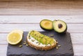 Food, breakfast, and lunch concept. Fresh healthy rye bread sandwich with cheese and avocado on a wooden table - light eating Royalty Free Stock Photo