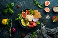 Food. Buddha bowl: noodles with avocado, figs, chia and lettuce in a black stone plate. Top view. Royalty Free Stock Photo