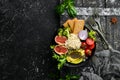 Food. Buddha bowl: noodles with avocado, figs, chia and lettuce in a black stone plate. Top view.