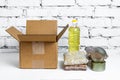 Food in cardboard donation box on a white background. Anti-crisis stock of essential goods for period of quarantine isolation.