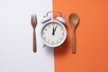 Food clock for lunch. Healthy food concept on white and orange background Royalty Free Stock Photo