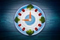 Food clock with vegetables, Healthy food concept, on wooden table Royalty Free Stock Photo