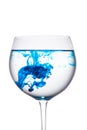 Food coloring diffuse in water inside wine glass area for slogan or advertising text message, white background. Royalty Free Stock Photo