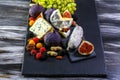 Food composition with assorted cheese and berries of wine and fruits on dark tabletop