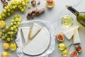 food composition with brie cheese wine grape and bread on white