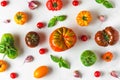 Food composition. various colorful organic tomatoes, pepper vegetables, garlic and basil on white background. top view Royalty Free Stock Photo