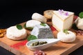 Food concept assortment French organic fresh goat cheese on wooden cheese board on black background with copy space