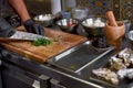 Food concept. The chef cuts the greens, prepares the ingredients for the dish on the table in the kitchen.