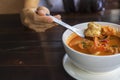 Close up Woman hand hold a spoon with shrimp from Tom Yum Kung,  With copy space for text or design Royalty Free Stock Photo