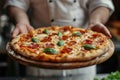 Food concept. A happy professional chef presents freshly prepared pizza from the oven Royalty Free Stock Photo