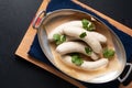 Food concept homemade organic German white sausage Weisswurst in aluminum tray on black slate stone with copy space