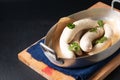 Food concept homemade organic German white sausage Weisswurst in aluminum tray on black slate stone with copy space