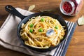 Food concept homemade spaghetti creamy white sauce in cast-iron skillet pan on wood