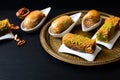 Food concept Oriental arab dessert baklava walnuts and rolled Kanafeh on black slate board with copy space Royalty Free Stock Photo