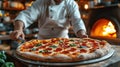 Food concept. Preparing traditional italian pizza. Young smiling chef in uniform Royalty Free Stock Photo