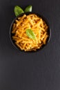 Food concept raw organic Italian Fusili pasta in black bowl on black slate board with copy space