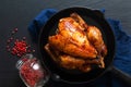 Food concept Roasted, Grilled Whole organic chicken in skillet iron pan on black slate stone board background