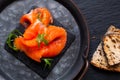 Food concept smoked Trout or Salmom fish slices on black slate stone board with copy space Royalty Free Stock Photo