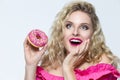 Food Concepts. Cute and Funny  Caucasian Blond Girl With Pink Doughnut in Hands. Posing With Excited Facial Expression and Looking Royalty Free Stock Photo