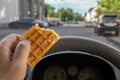 Food in the hand of a car driver while driving in the city