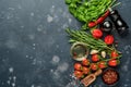 Food cooking background. Fresh rosemary, cilantro, basil, cherry tomatoes, peppers and olive oil, spices herbs and vegetables at Royalty Free Stock Photo