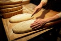 Baker making bread and cutting dough at bakery Royalty Free Stock Photo