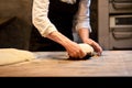 Baker portioning dough with bench cutter at bakery Royalty Free Stock Photo