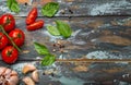 Food cooking border with cherry tomatoes, fresh green basil and garlic cloves top view on rustic colourful wooden