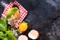 Food Cooking concept background. Ingredients for traditional Italian homemade pasta tomatoes, raw egg, basil leaf on the dark Royalty Free Stock Photo