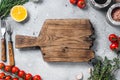 Food cooking and healthy eating background with wooden cutting board and fresh seasoning, herbs and vegetables. Gray Royalty Free Stock Photo