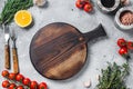 Food cooking and healthy eating background with wooden cutting board and fresh seasoning, herbs and vegetables. Gray Royalty Free Stock Photo