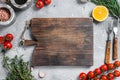 Food cooking and healthy eating background with wooden cutting board and fresh seasoning, herbs and vegetables. Gray Royalty Free Stock Photo