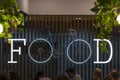 Food court at the Vilnius Airport. The bicycle hangs on the wall, its wheels glow and form two letters `o` in the word `food`