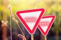 Food crisis concept. Two red road signs. Defocus blank empty triangle red warning road sign on nature background. Hunger Royalty Free Stock Photo