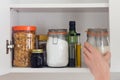 Food cupboard, pantry with jars, hand Royalty Free Stock Photo