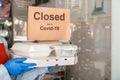 Food for delivery against sign closed due to covid 19. Woman waiter in protective medical mask and gloves work with