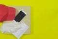 Food delivery concept. Pizza boxes with hat, Alcohol Hand Gel bottle, medical rubber gloves and mask on yellow background