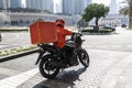 A food delivery courier is driving an order to a customer's home on a moped. takeaway food during quarantine