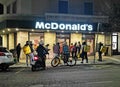 Food delivery couriers, mainly Glovo, waiting outside Mac Donald fast food for online orders pickup