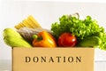 Food delivery. Food donation on table. Help cardboard box wiht various canned food, cereals, pasta and vegetables