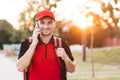 Food delivery guy with red backpack deliver orders. Male courier with isothermal food case box on electric scooter