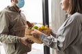 food delivery man in mask giving order to customer