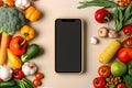 Food delivery. Phone with empty screen and organic vegetables around. Online grocery shopping app and home delivery Royalty Free Stock Photo
