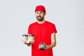 Food delivery, quarantine, stay home and order online concept. Cheeky courier in red uniform cap and t-shirt, wink to