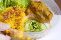 Food Delivery service: Chicken Biryani Muslim yellow rice with chicken opening cling wrap and take out food in plastic box. Royalty Free Stock Photo