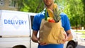 Food delivery service, male worker holding grocery bag, express food order Royalty Free Stock Photo