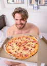 Food delivery service. Man bearded handsome bachelor eating cheesy food for breakfast in bed. Man likes pizza for