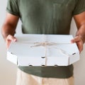 Food delivery service. A man holding a box of pizza on a white background. Close up Royalty Free Stock Photo