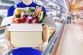 Food delivery service for order online grocery shopping concept. Delivery man in blue uniform hand holding paper box package. Royalty Free Stock Photo